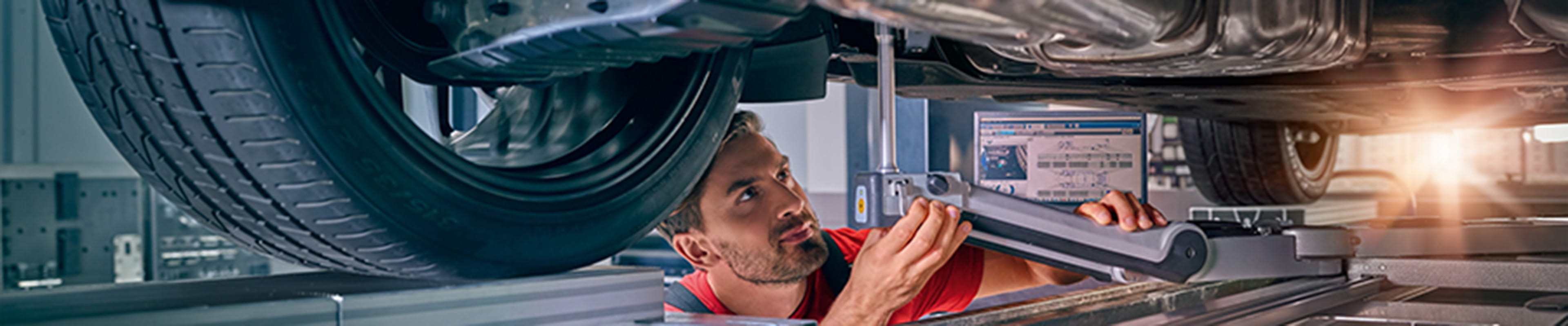 Porsche mechanic checking undercarriage