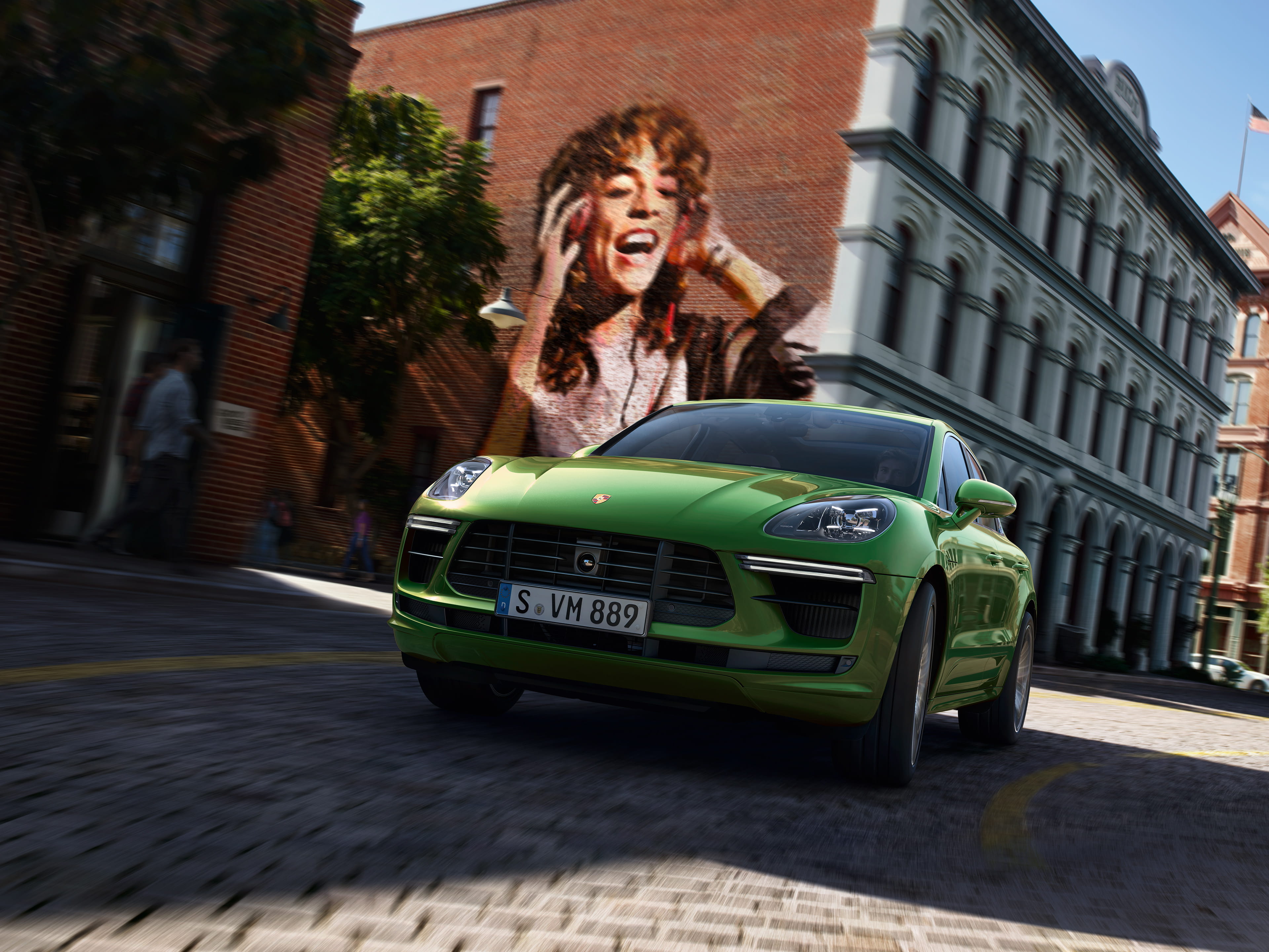 Green Macan GTS in a thrilling city