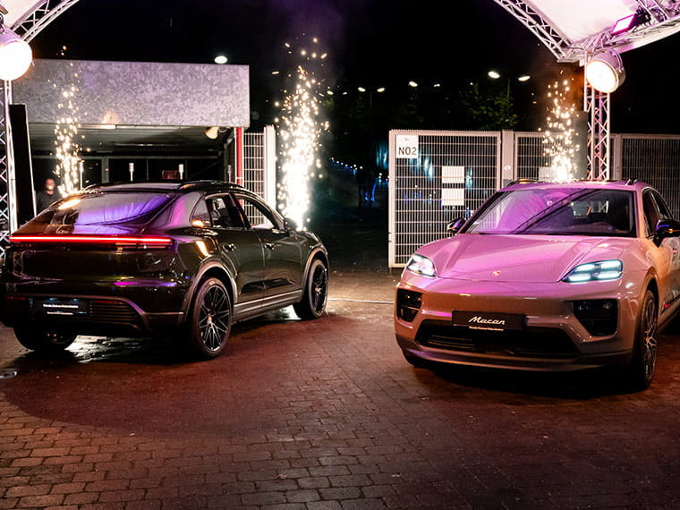 Zwei Porsche Fahrzeuge vor einer Festhalle