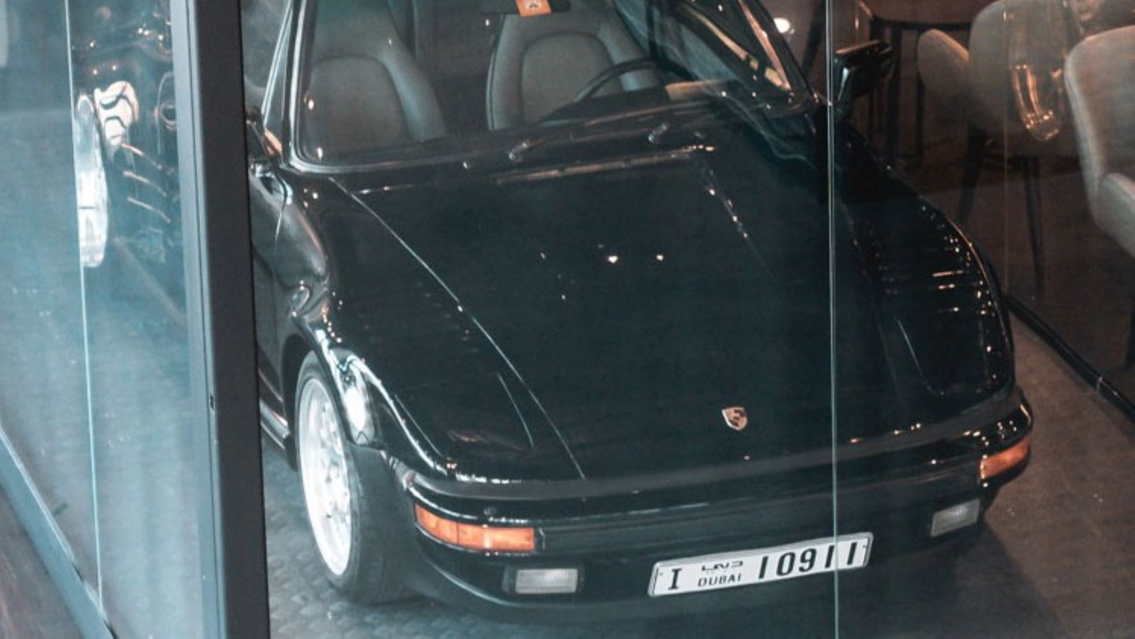 this is a black classic Porsche on display in glass